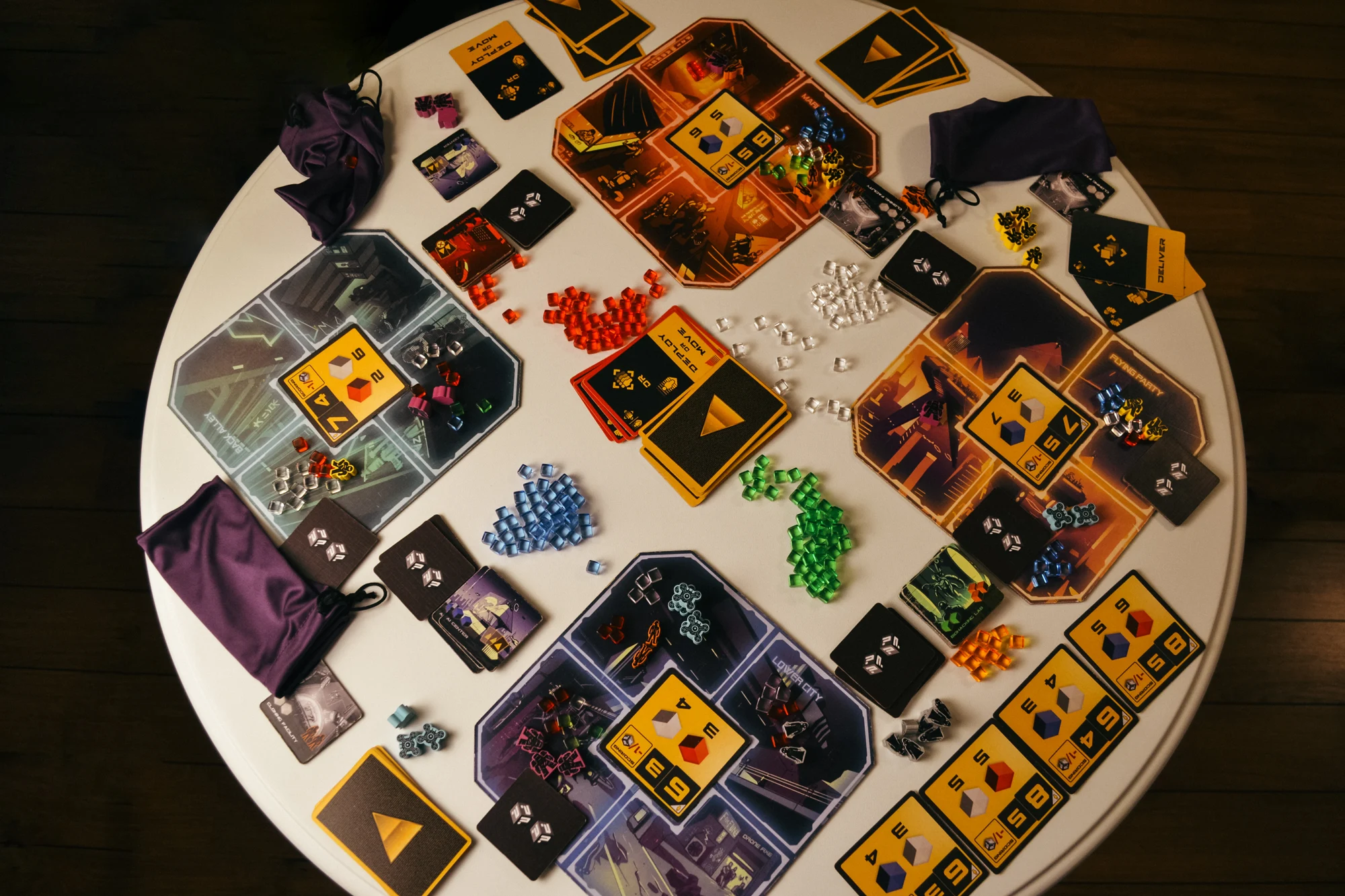 Overhead view of Hyperwars with its illustrated district boards, cards, colored agents, and goods